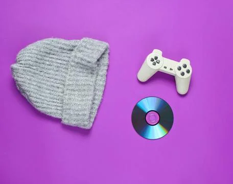 CD disk, gamepad, warm hat on a purple background. Pop culture 80s. Top view, 写真素材