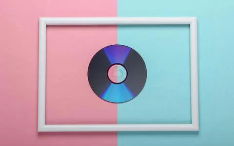 CD disk in white frame on pink blue pastel background. Top view 库存照片