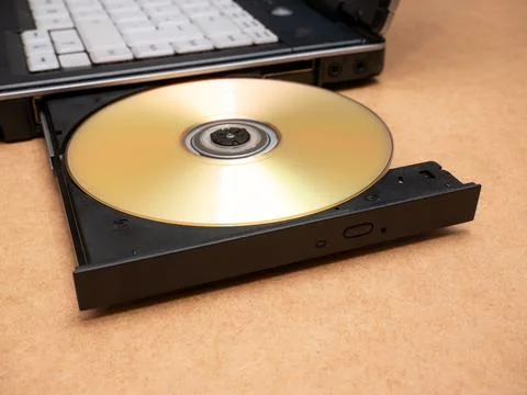CD DVD optical disc media inserted in a laptop computer disc tray, closeup Stock Photos