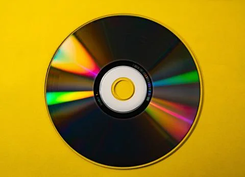 CD DVD on yellow background rainbow lights Stock Photos