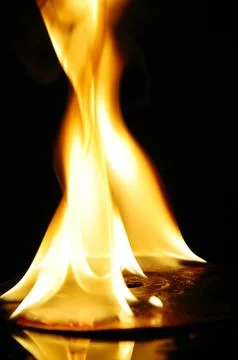 A CD or DVD disc burning in flames Stock Photos