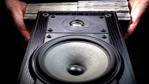 CDs being placed on top of a speaker cabinet. Stock Footage 90549516