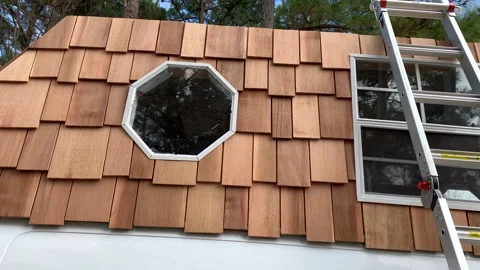 Cedar shingles and octagon windows on roof of tiny house/van conversion Stock Footage 146756215