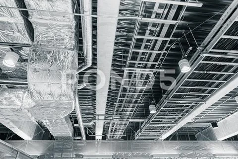 Ceiling air pipe air ventilation and manged data cables in a cableway on the Stock Photos