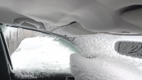 Ceiling and windscreen of car interior coated in fresh white snow Stock Footage 319554756