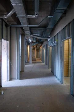 On a ceiling of a construction site runs heating and ventilation pipes Stock Photos