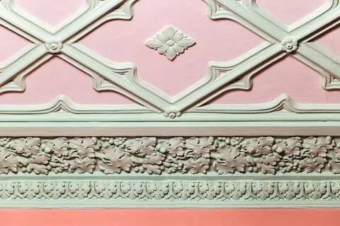 Ceiling design elements. Light green gypsum bas-relief over pink background Stock Photos