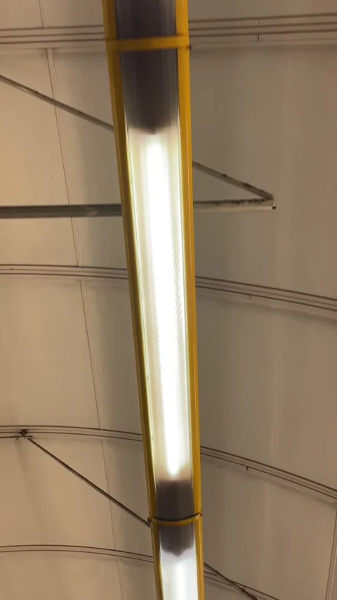 Ceiling with exposed piping and gentle glowing light from tube Stock Footage 335368410