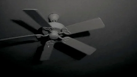 Ceiling fan begins rotating in dark room at night with eerie shadows. Stock Footage 105200746