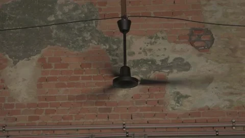 The ceiling fan rotates against the background of a textured brick wall. Cooling Stock Footage 157229843