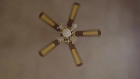 Ceiling fan rotating indoors with multiple blades and integrated lights Stock Footage 340007542