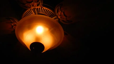 Ceiling fan spinning with light on in a dark room Video stock 45593418