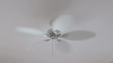 Ceiling fan spins rapidly in a bright indoor space during daytime, bringing cool Stock Footage 306410161