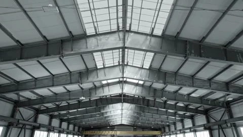 Ceiling of an industrial warehouse or workshop, with a large window. The beams Stock Footage 297178205