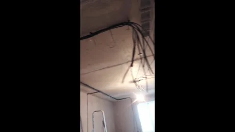 Ceiling inspection and cable tracing in a dim room during a renovation project Stock Footage 327180797