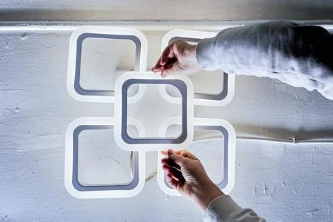 Ceiling light installation scene showing five interconnected square modules.. Stock Photos