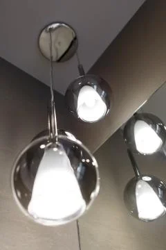 Ceiling light. Modern three-lamp chandelier. Lamp in the bathroom. Reflected  Stock Photos