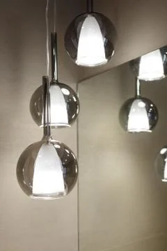 Ceiling light. Modern three-lamp chandelier. Lamp in the bathroom. Reflected  Stock Photos