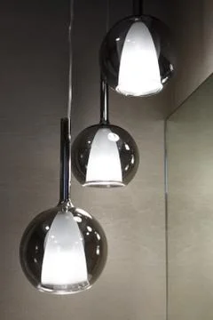 Ceiling light. Modern three-lamp chandelier. Lamp in the bathroom. Reflected  Stock Photos