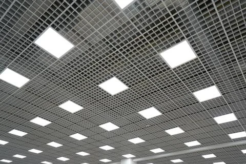 Ceiling lighting in the form of squares in a large room in a mall or warehous Stock Photos