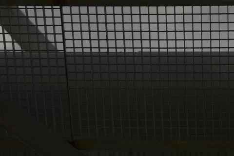 Ceiling made of metal mesh with stark shadows and utilitarian design Stock Photos