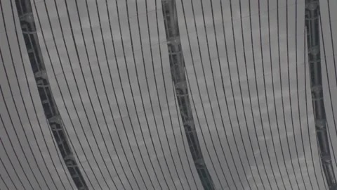 The ceiling of a modern airport terminal reflects the shadows of pedestrians. Stock Footage 345471138