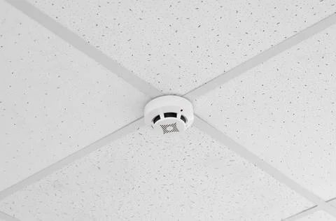 Ceiling-mounted fire safety sensor. Modern ceiling smoke detector Stock Photos
