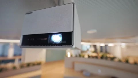 Ceiling-mounted projector illuminates a bright display in a modern office space Stock Footage 335945321