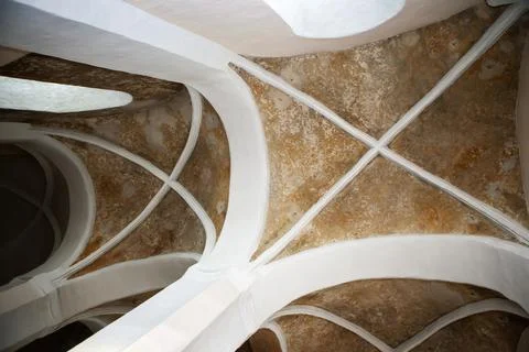 The ceiling shows a design with arches and patterns in a historic building. S Stock Photos