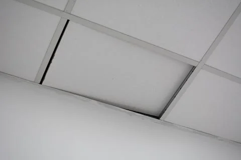 Ceiling tiles peeled off the ceiling. Poor quality damaged pvc ceiling tile.. Stock Photos