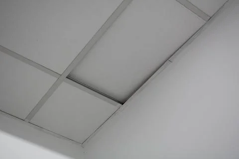 Ceiling tiles peeled off the ceiling. Poor quality damaged pvc ceiling tile.. Stock Photos