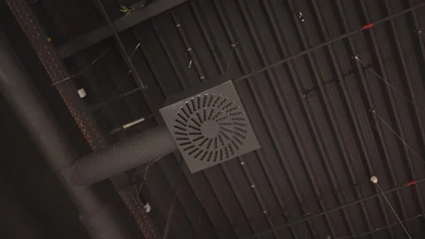 Ceiling ventilation diffuser connects to exposed industrial air ducts Stock Footage 342914728