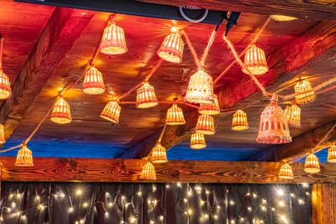 Ceiling with wooden beams, cross pattern of lights, upside-down paper lantern 写真素材