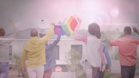 Celebrating with rainbow flag, diverse group showing unity and pride outdoors Stock Footage 305117305