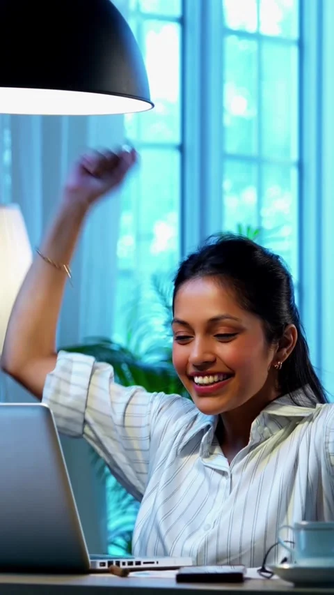 Celebrating success using laptop, Indian businesswoman shows joy Stock Footage 342572825