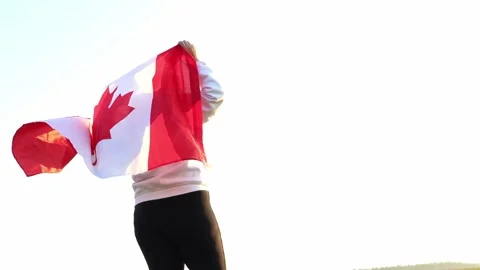 Celebrating unity and pride under the Canadian sky with a vibrant flag 스톡 동영상 295256500