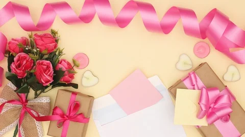 Celebration decor - Pink note and roses, gifts and ribbons appear-Stop motion Stock-Footage 121348336