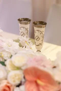 Celebration event with decorated glasses on a table surrounded by flowers i.. Stock Photos