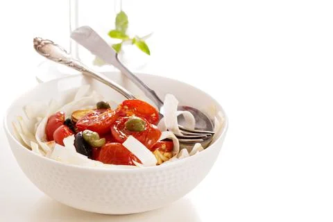Celery root pasta with tomatoes, olives and capers Stock Photos