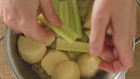 Celery soup recipe. Green celery sticks, potatoes, herbs, onion, and broth Stock Footage 224025716