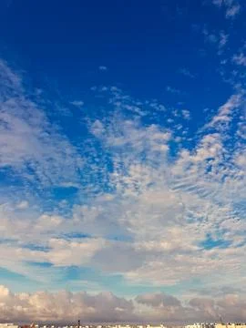 Celestial Canvas: A blue sky dotted with fluffy white clouds, where radiant sun Stock Photos