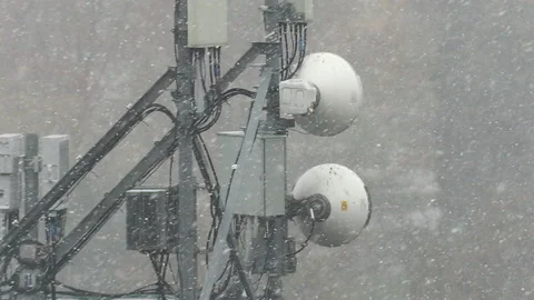 Cell antenna tower infrastructure with snow falling Stock Footage 164417073