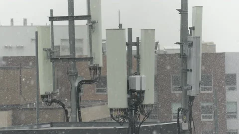 Cell antenna tower infrastructure with snow falling Stock Footage 164417427