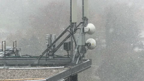 Cell antenna tower infrastructure with snow falling Stock Footage 164418111