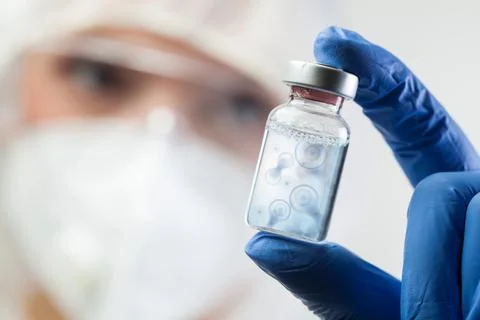 Cell division process conceptual illustration,lab scientist holding ampoule v Foto stock