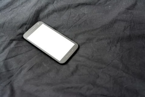 Cell Phone on Black Blanket White Screen Isolated Simple Background Fabric Stock Photos