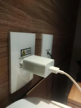 Cell phone charger in the socket Stock Photos