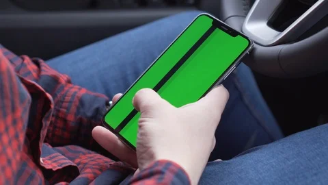 Cell phone with green screen in hands, sitting in car, working in application Stock Footage 116763525