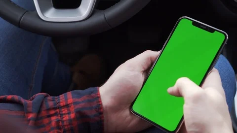 Cell phone with green screen in hands, sitting in car, working in application Stock Footage 116763968