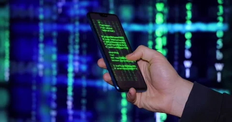 Cell phone in the hand of a young hacker or programmer Stock-Footage 263043344